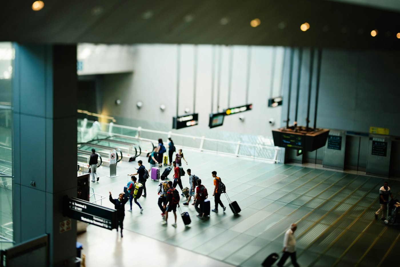 Travellers walking through a busy airport terminal